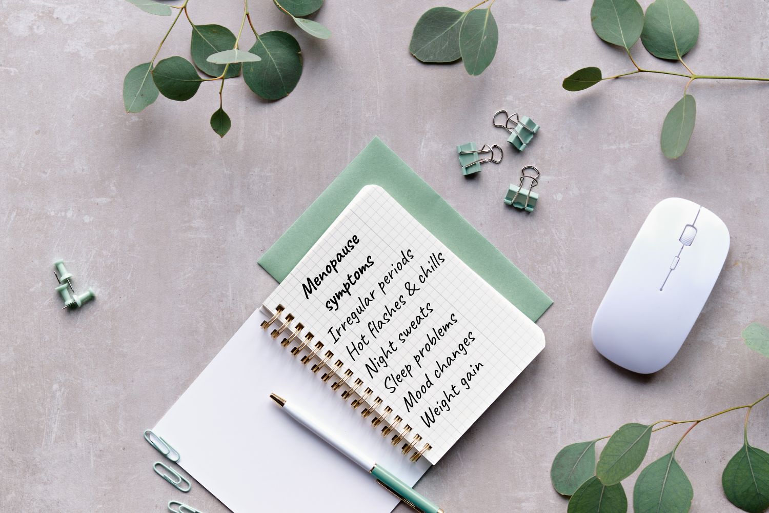 Un carnet sur une table avec un stylo à coté ou sont notés les symptômes périménopause ou préménopause