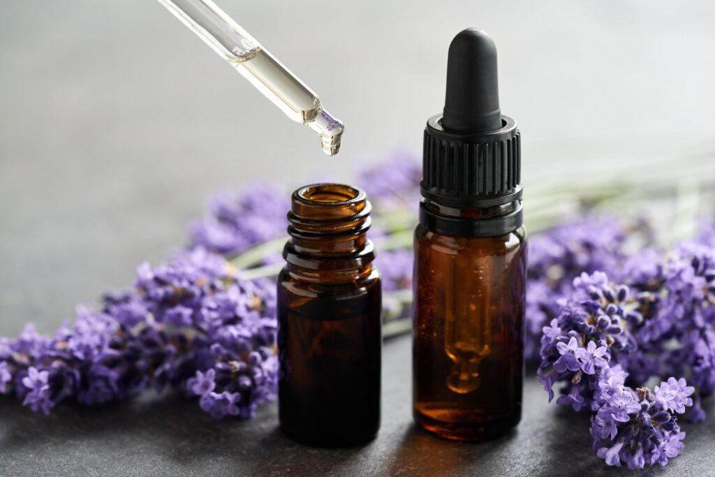 Comment gérer les bouffées de chaleur au bureau ? 2 De l'huile essentielle avec une pipette posée sur une table à coté de brins de lavande pour suggérer comment gérer les bouffées de chaleur au bureau.