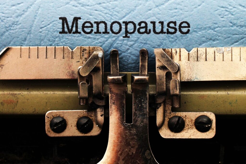 Le mot ménopause écrit à la machine pour illustrer les conséquences de la ménopause au travail