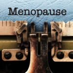 Le mot ménopause écrit à la machine pour illustrer les conséquences de la ménopause au travail