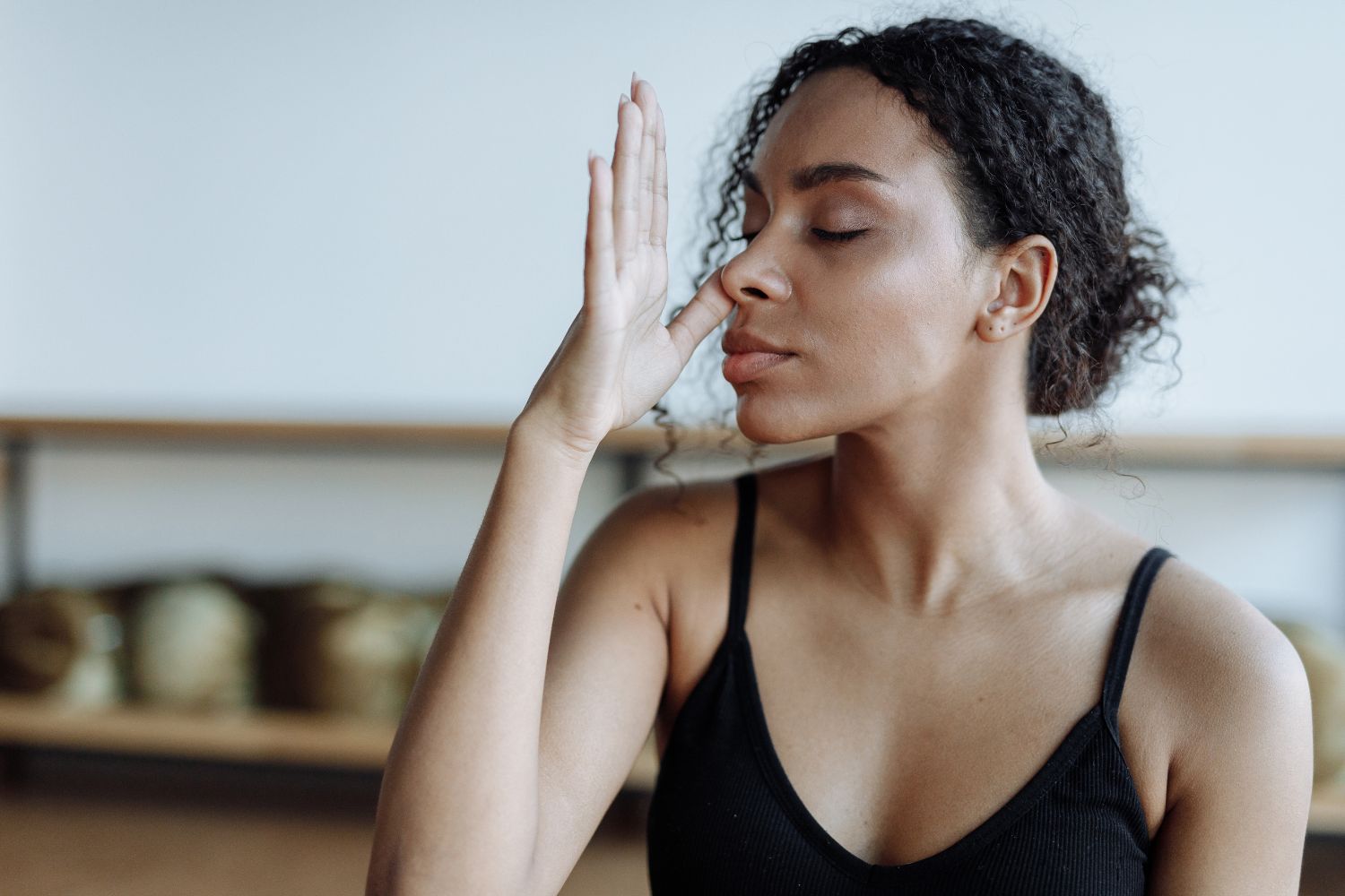Une femme métissée fait un exercice de respiration alternée menopause