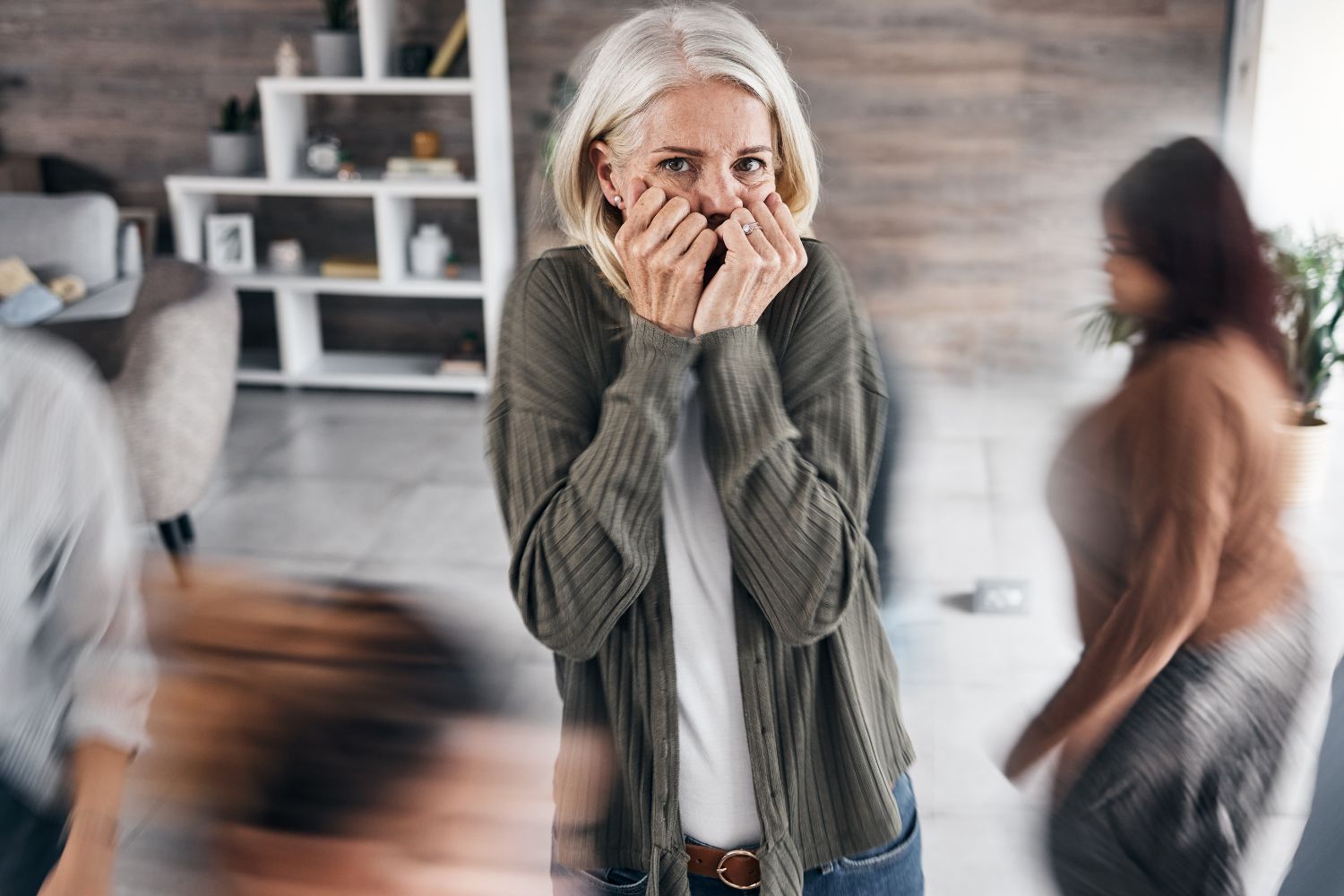 Une femme les cheveux blanc se tient le visage pour illustrer l'article angoisse et menopause