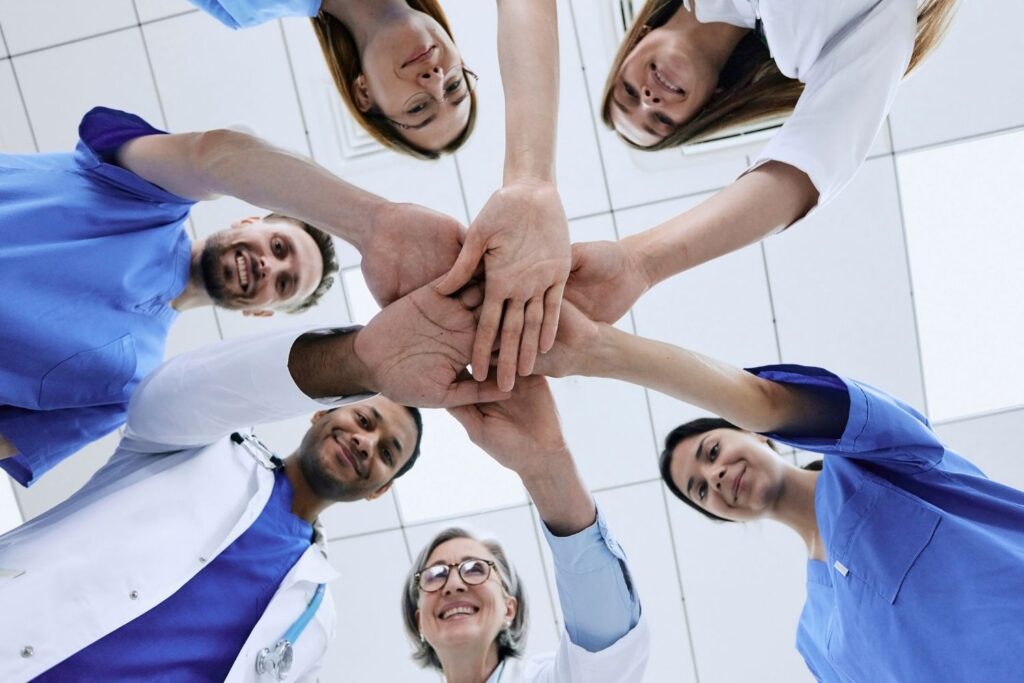 2 hommes et 4 femmes habillés en bleu et blanc se joignent la main au centre pour illustrer l'article angoisse et menopause