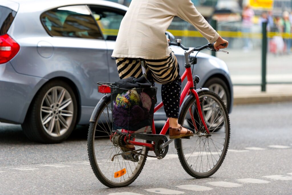 un vélo en ville avec une femme dessus pour illustrer l'article ménopause et sport