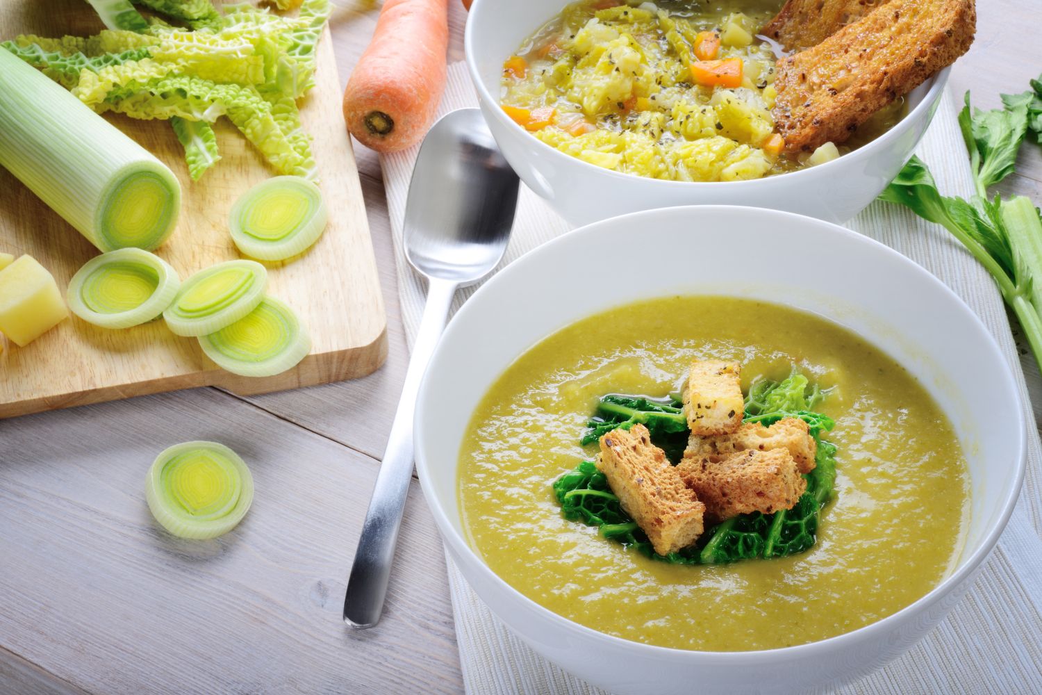 un velouté de courgette dans un contenant blanc opaque et des poireaux pour un menu semaine regime ménopause