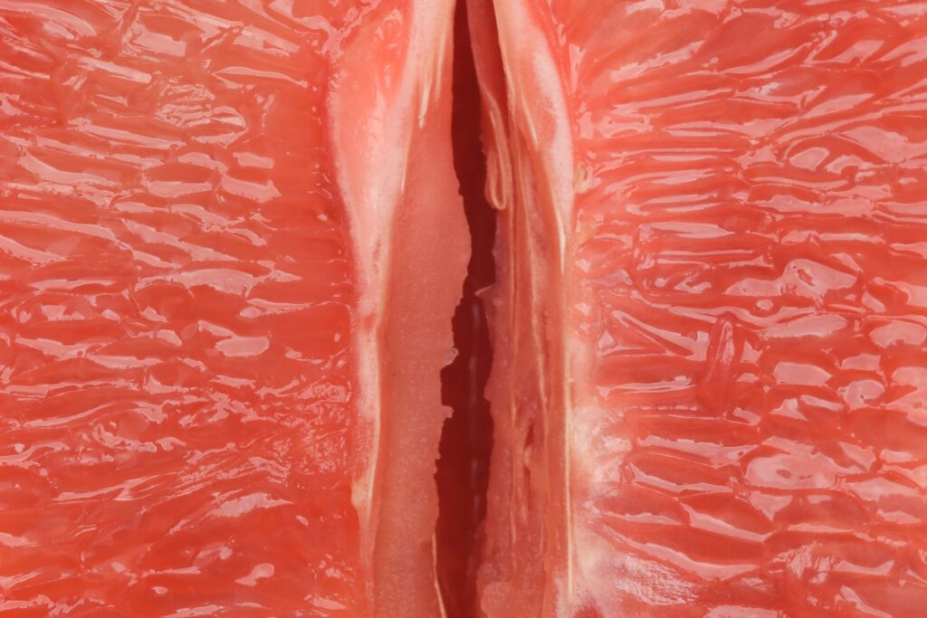 Zoom sur le centre d'un demi pamplemousse rose pour illustrer l'article comment choisir son lubrifiant à la ménopause.