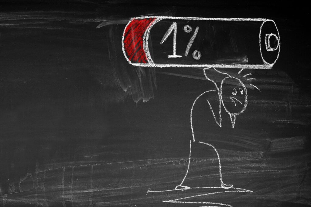 un dessin a la craie d'un personne qui porte une pile avec 1% de charge pour illustrer une baisse d'envie à la ménopause