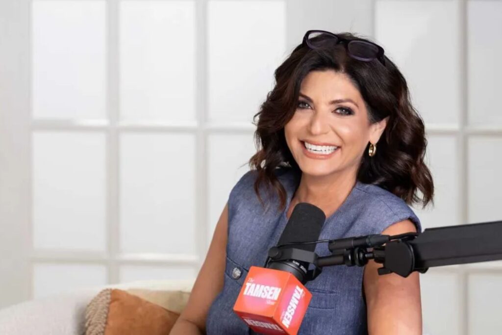 Palpitations à la ménopause : causes, signaux d’alerte et solutions 2 Tamsen Fadal avec un grand sourire devant un micro pour parler de palpitations à la ménopause