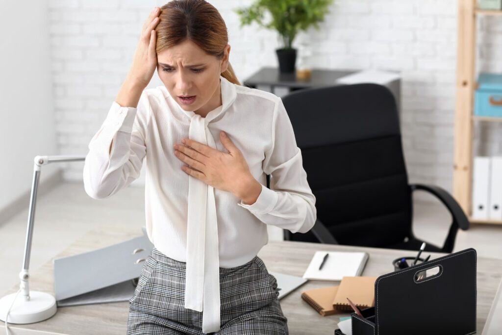 une femme habillée en blanc et gris pour illustrer l'article palpitations à la ménopause