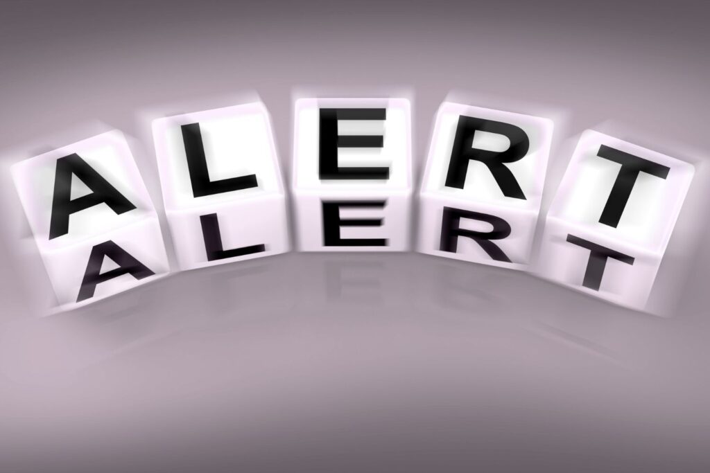 Des cubes avec des lettres formant le mot alerte en arc sur un fond gris pour illustrer l'article peau sèche à la ménopause