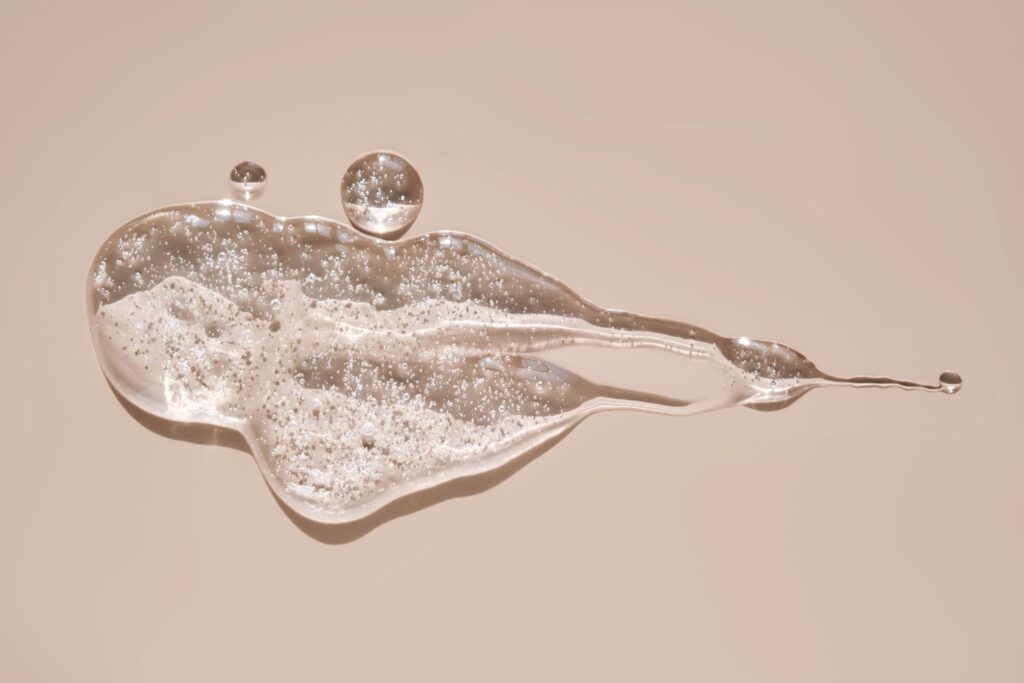 du lubrifiant translucide sur un fond beige pour illustrer l'article sécheresse intime à la menopause, témoignage de Carole