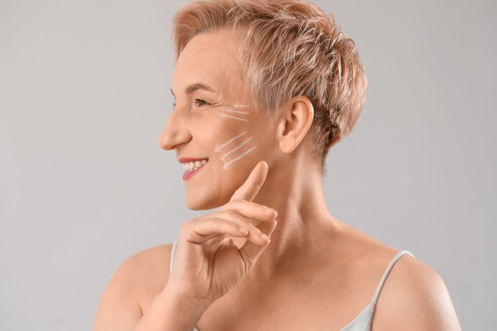 Une femme la cinquantaine de profil avec les cheveux blond et court souriante et des traits blanc sur la joue dans pour illustrer l'article sperme de saumon en injection